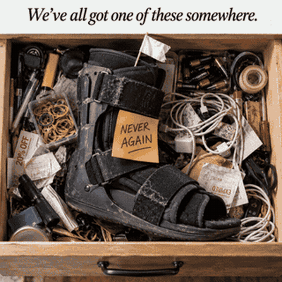 Junk drawer with a discarded posterior night boot and a 'NEVER AGAIN' sticky note — where failed devices end up.